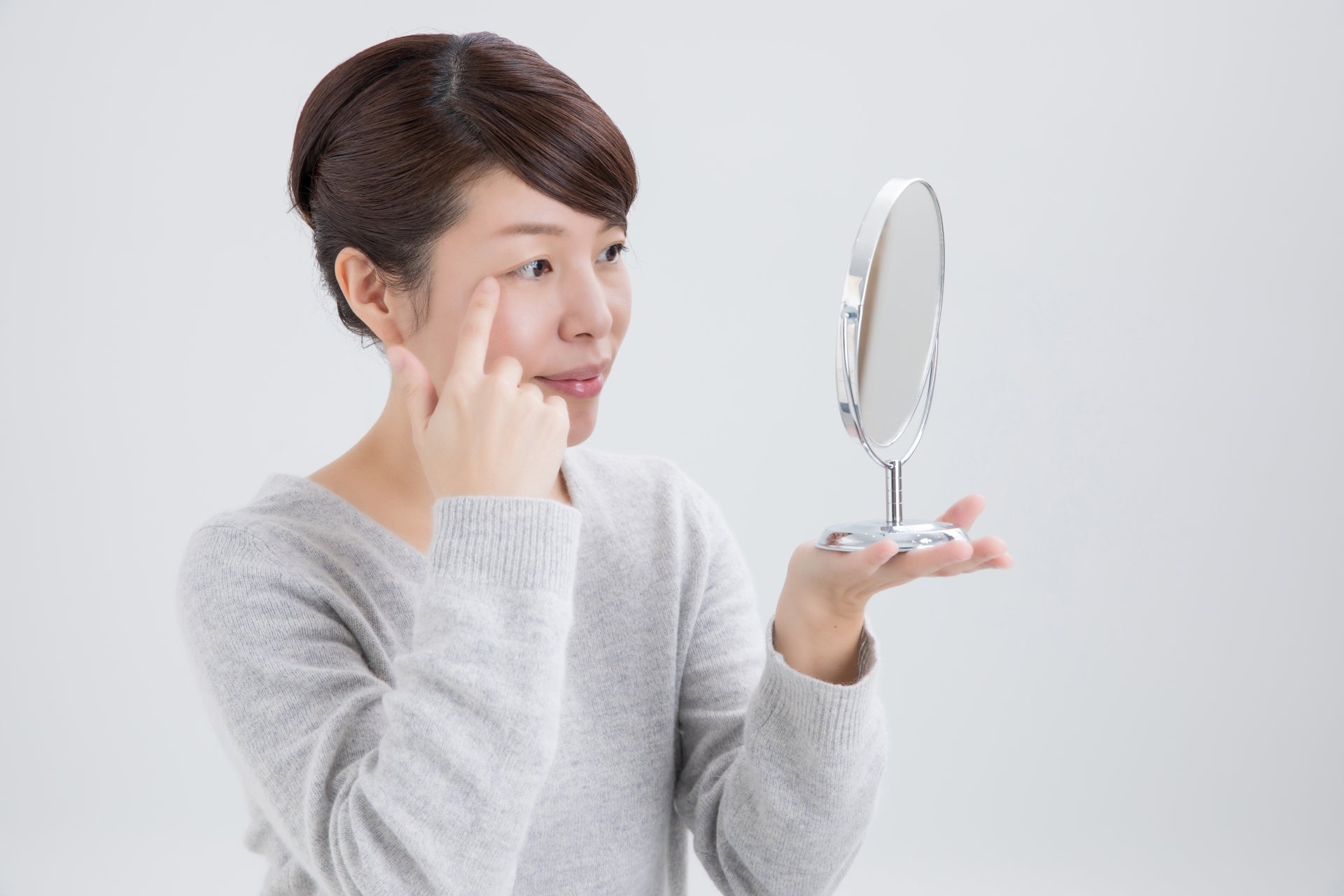鏡で目を確認している女性
