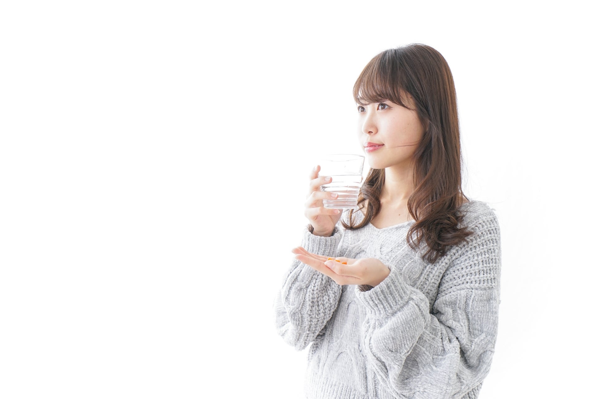 サプリを飲む女性