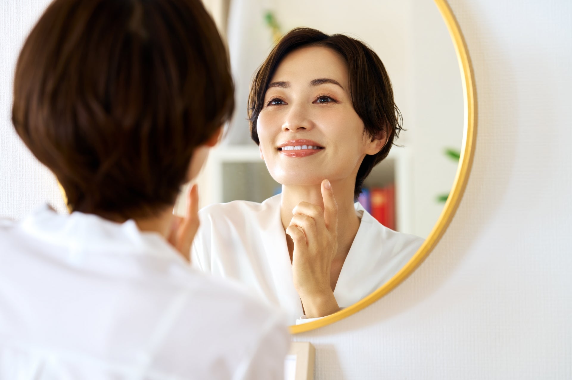 笑顔で鏡を見る女性