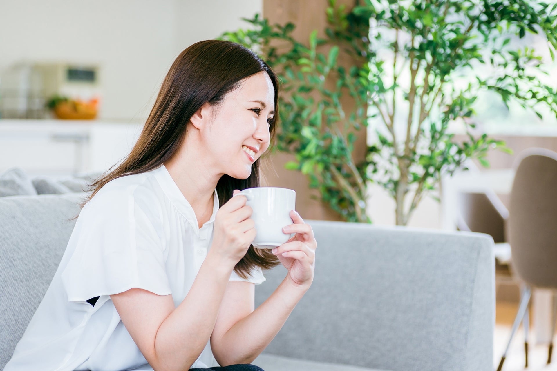 マグカップを持ち談笑する女性