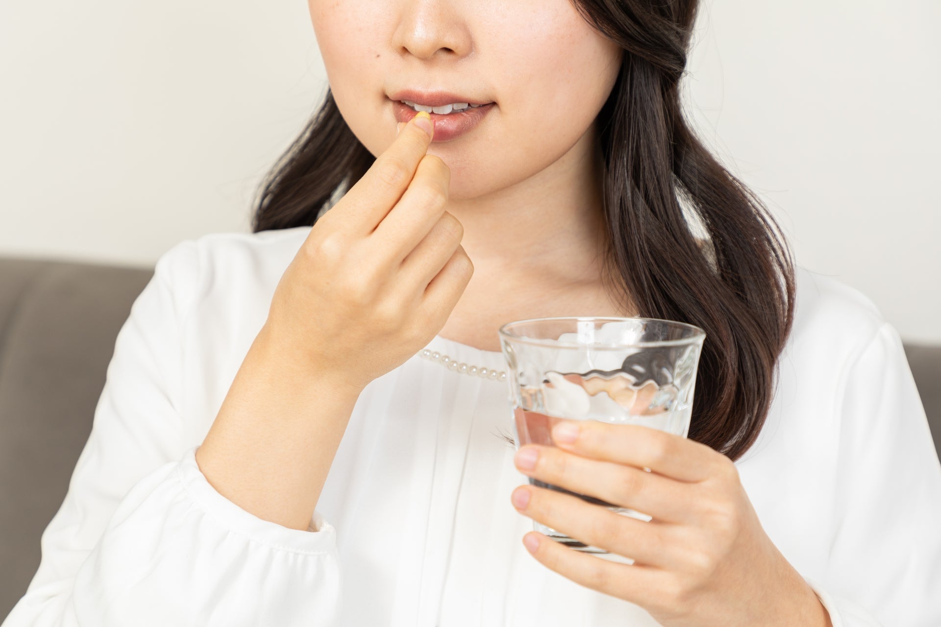 サプリメントを飲む女性