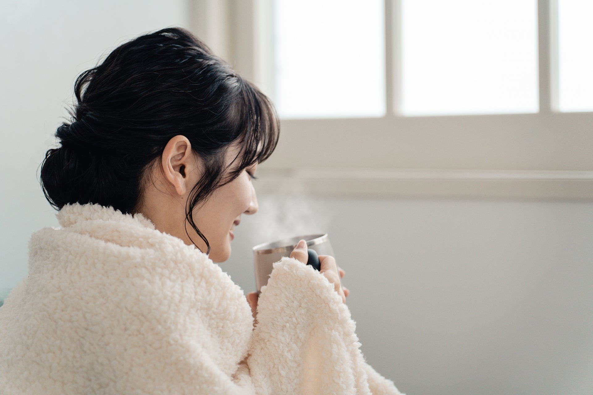 女性が温かい飲み物を飲んでいる