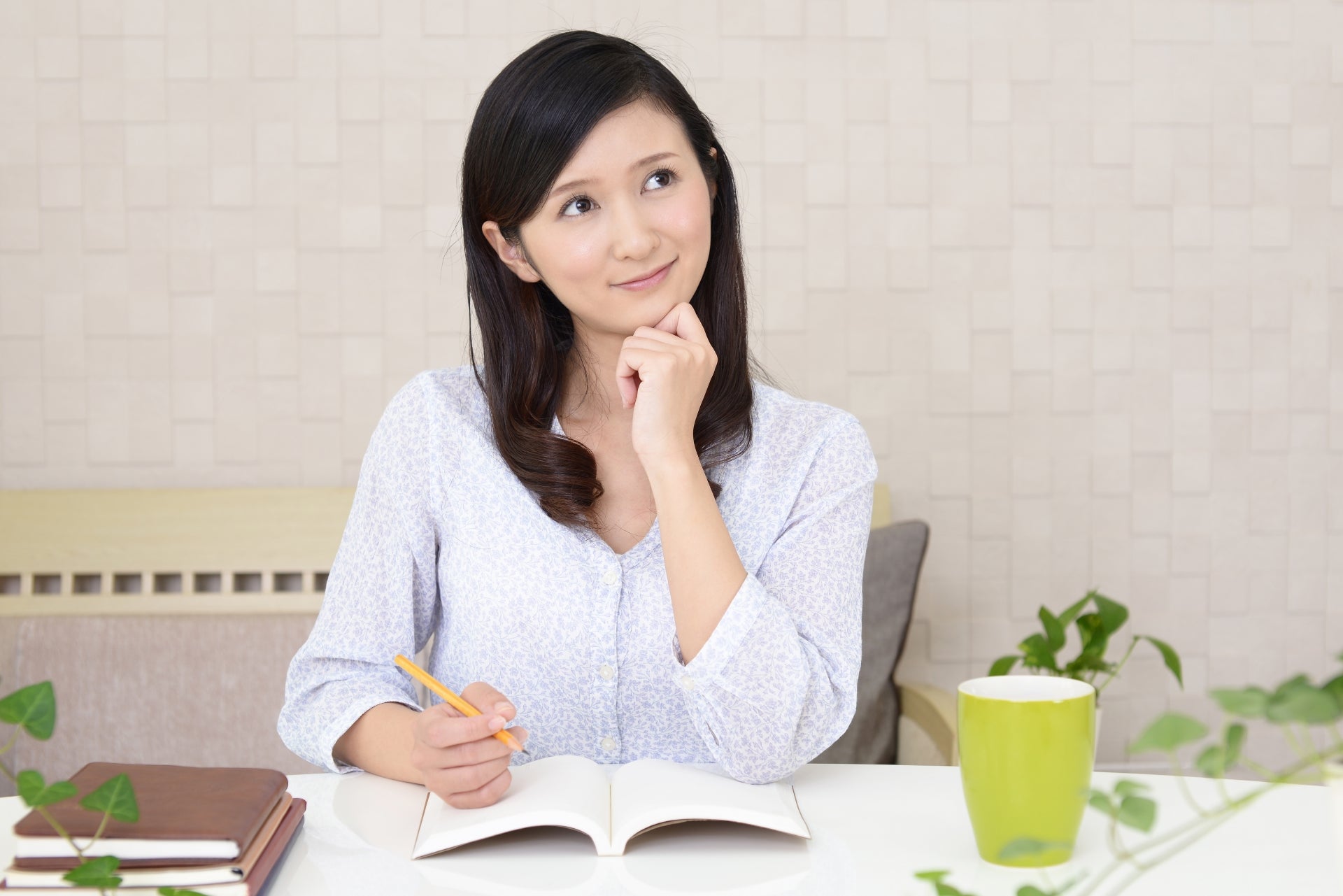 思い出しながらノートを書く女性