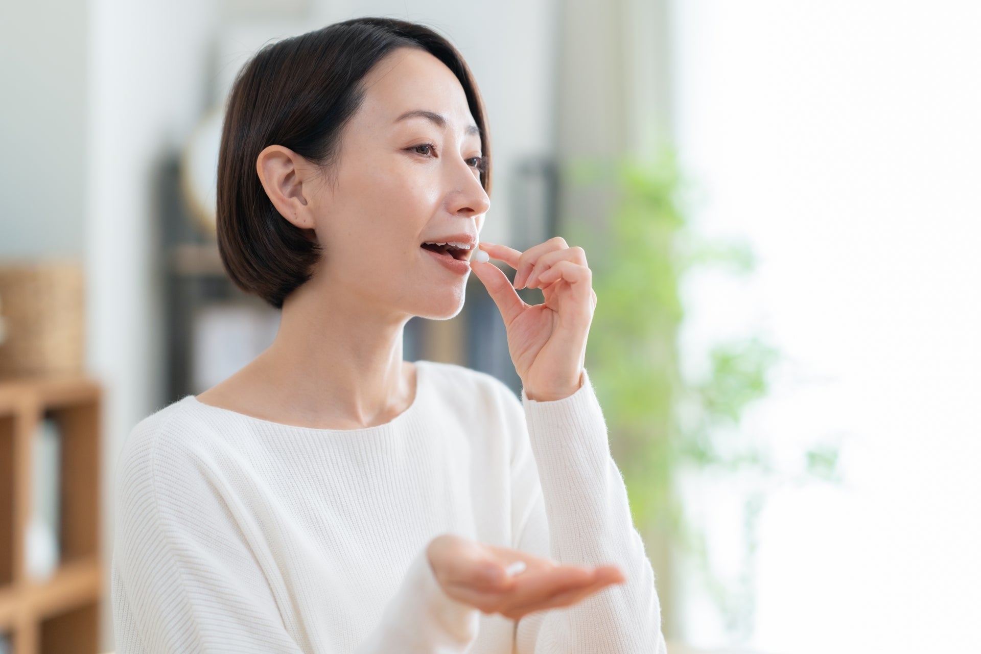 サプリメントを飲む女性