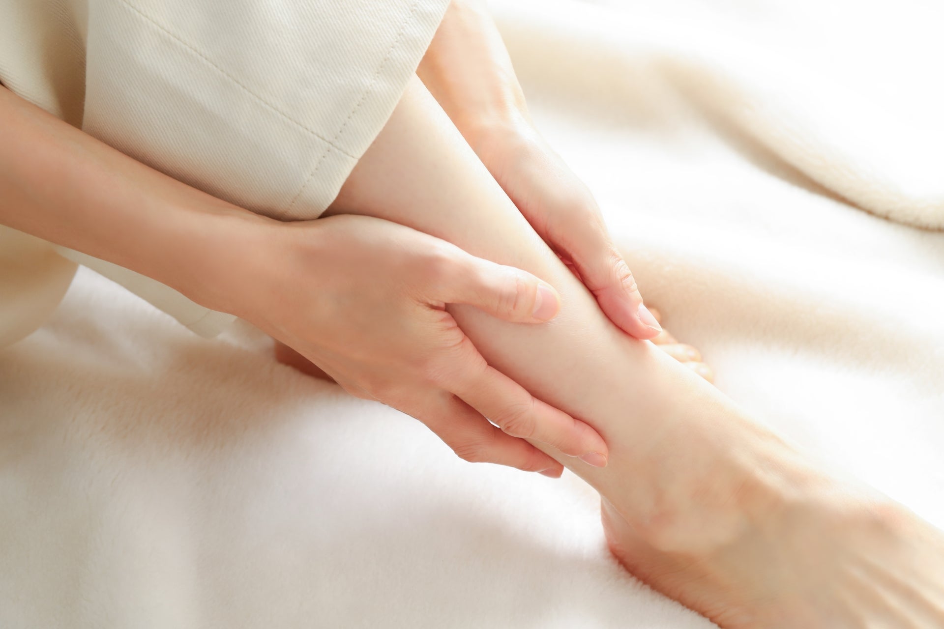 足の関節をいたわる女性