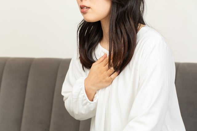 胸を抑え苦しそうにしている女性