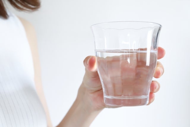 水の入ったコップを持つ女性