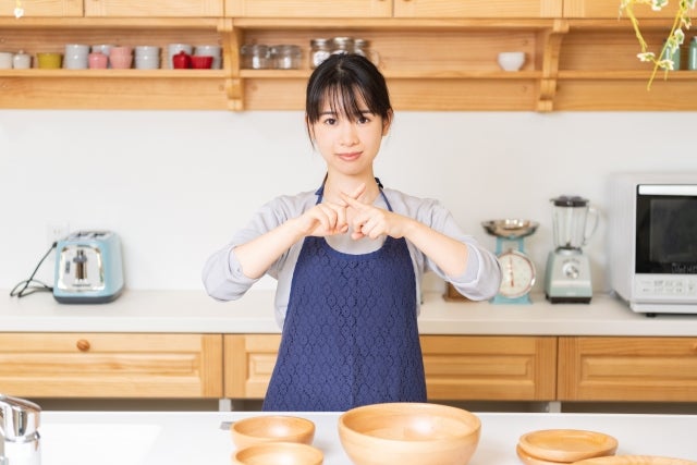 バツ印をして禁止事項を説明しようとしているいる女性の写真