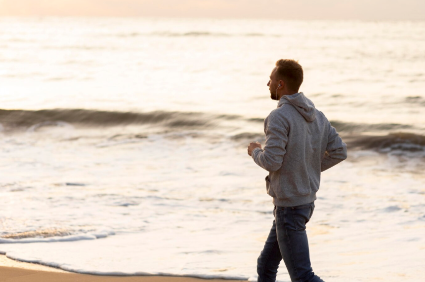 海辺で走る健康的な男性