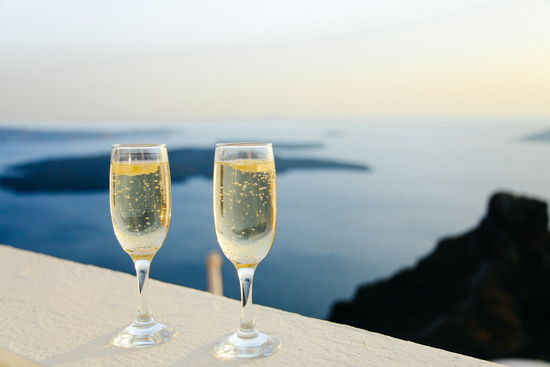海の見える場所にあるテーブルに置かれた炭酸飲料の入った2つのグラス