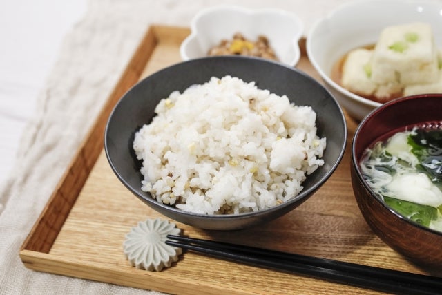 木製のトレイ上の器に盛られたご飯と味噌汁とおかず