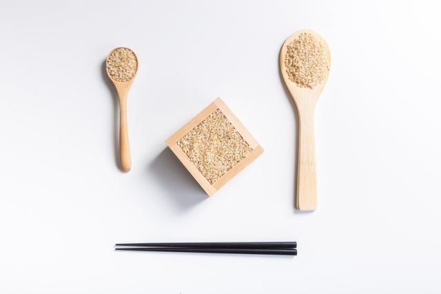 木のスプーンと枡に入った玄米、一膳の箸
