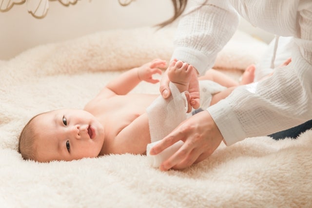 女性に包帯を巻かれている赤ちゃん