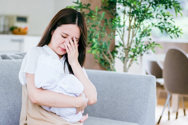 頭を抱える産後の女性