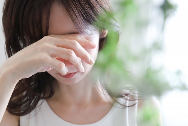 手顔を覆い塞ぎ込む人