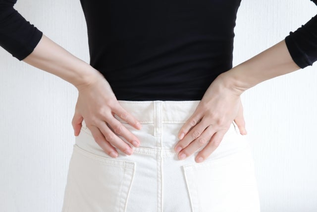 腰のあたりに手を当てる女性の後ろ姿