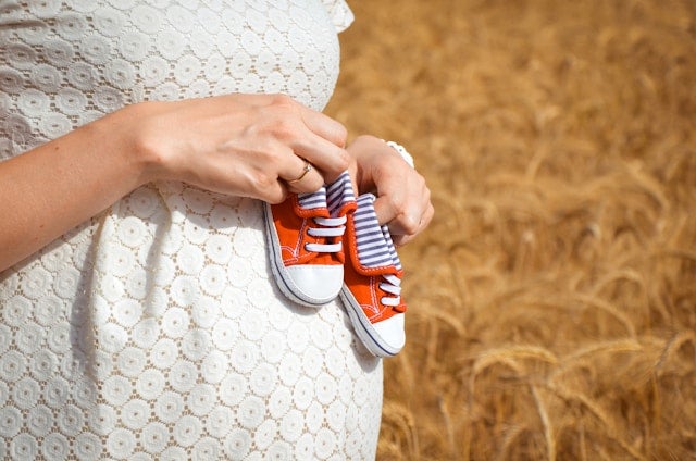 小さな靴を手に持つ妊婦さん