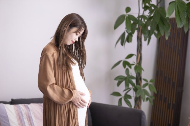 お腹に手を当てる妊婦さん
