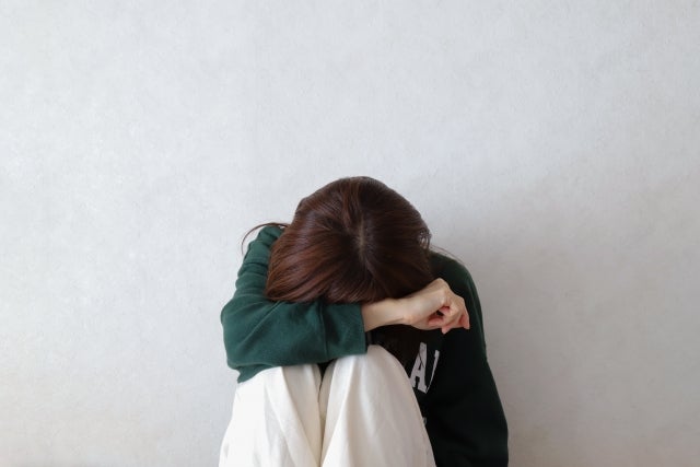 座り込んで突っ伏している女性
