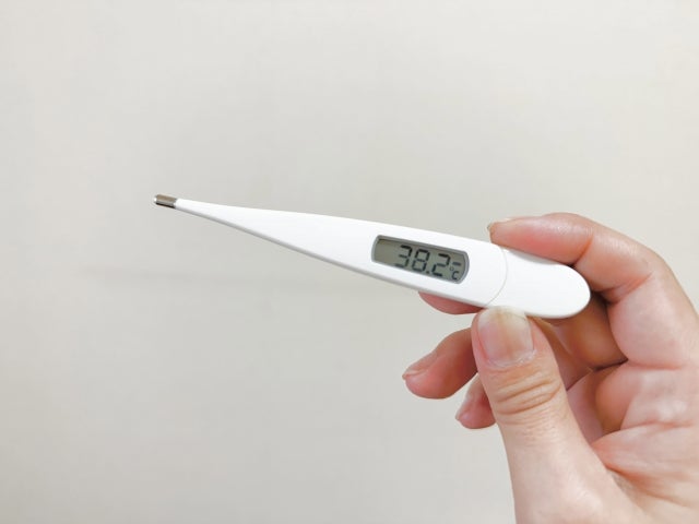 手に持った38.2度を示す体温計